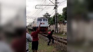 Kid Lays Down in Front of Train to the Surprise of others watching