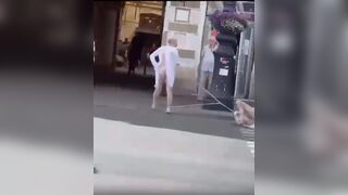 Two Russian men half-naked walking the streets in Russia. One of them is being dragged