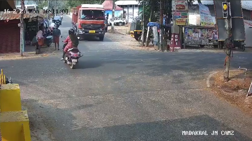Woman on Motorcycle looks both ways but still can't get across the Street