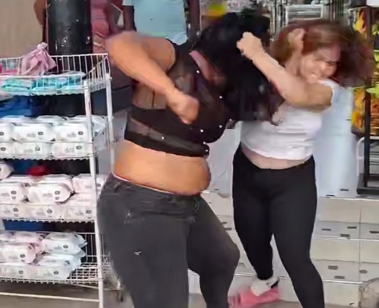 Two big woman fight each other over a Man of course