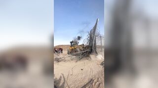 A Palestinian Bulldozer Smashing Open the Separation wall on the Gaza Strip border.