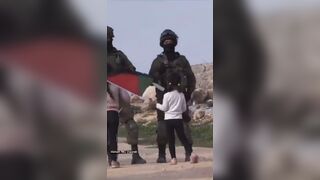 Moment from the War: Little Girl holds Palestine Flag Up and Blocks Israeli Soldiers