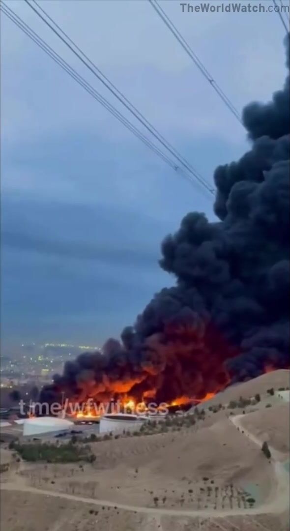 An oil facility in Tehran continues to burn after being hit overnight causing Oil rain (Watch until End)