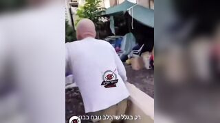 An Israeli man blocks a woman from entering a shelter because she has a dog.