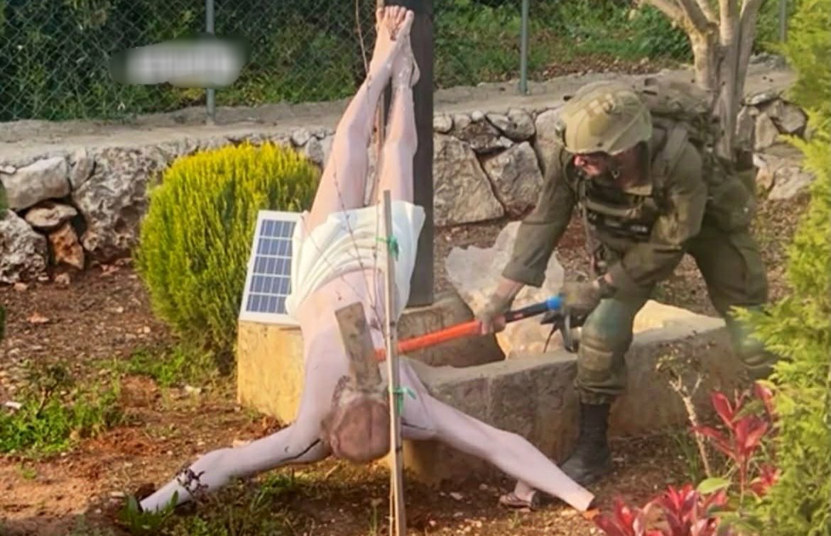 Israeli IDF soldier smashing the head of a Jesus Christ statue during operations in L