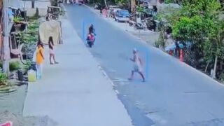 Woman trying to Cross the Road lines up perfectly with Biker