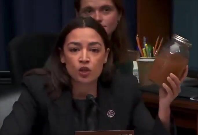 AOC held up a jar of drinking water from Morgan County, Georgia.