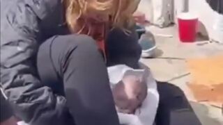 LA, USA. Homeless Woman has Baby on the Sidewalk as People Walk By