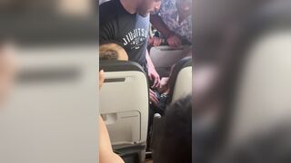 Passengers restrain a man onboard a Frontier Airlines flight to Chicago's O'Hare