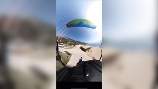 A man lands with a parachute and collides with a man