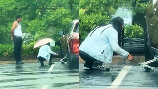 Man is going viral after being filmed watching his girlfriend change a car tire in the rain and not help