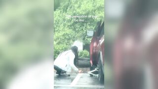 Man is going viral after being filmed watching his girlfriend change a car tire in the rain and not help