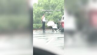 Man is going viral after being filmed watching his girlfriend change a car tire in the rain and not help