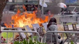 Alternate Footage of Trump Protester Setting Himself on Fire in NYC as Woman sits Down to Watch