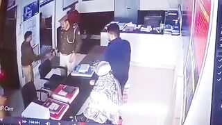 Watch the Woman Standing at the Counter in White...and the Officer who is Taking a Report