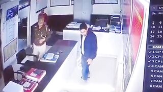 Watch the Woman Standing at the Counter in White...and the Officer who is Taking a Report