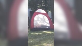 Tent Set Up right outside University People Strolling By as Sex Happens