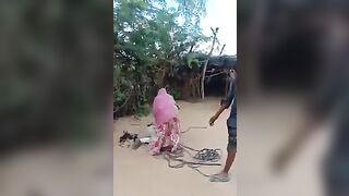 Indian Woman beats Tied Up Man with an Exe
