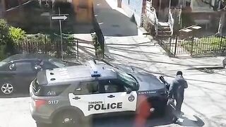 Female officer ran away as a man destroys her car and threw a stone at her