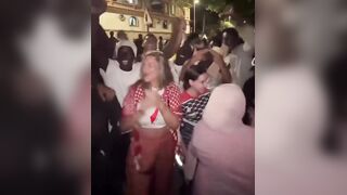 White Liberal Woman celebrates the invasion of thousands of African Men - with the invaders.