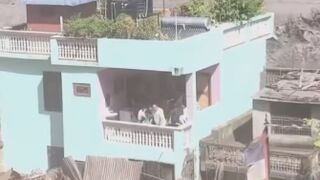 Terrifying footage shows a flash flood sweeping through the Nepal–Tibet border, trapping people on rooftops and balconies.
