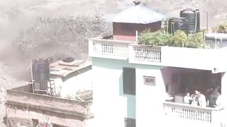 Terrifying footage shows a flash flood sweeping through the Nepal–Tibet border, trapping people on rooftops and balconies.