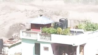 Terrifying footage shows a flash flood sweeping through the Nepal–Tibet border, trapping people on rooftops and balconies.