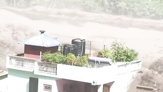 Terrifying footage shows a flash flood sweeping through the Nepal–Tibet border, trapping people on rooftops and balconies.