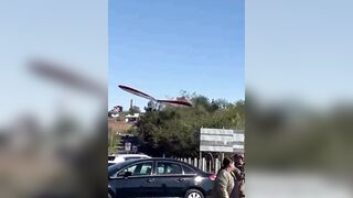 A hang glider pilot was injured after losing control and crashing onto a parked car