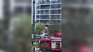 China: Man stuck in Fire Falls from Balcony and Hits a Rescuer on the Way Down (Watch Aftermath)