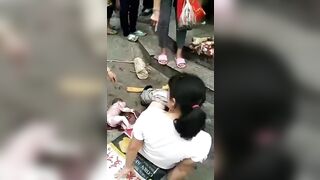 Only in China...Woman has Baby in the Middle of the Street Standing..the Baby Lived!