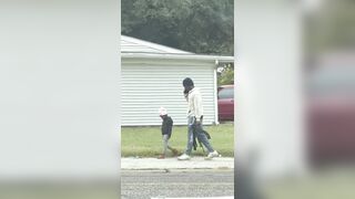 A father was filmed walking his little daughter to school... …armed with a AK-47
