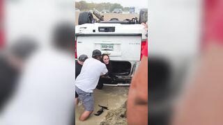 Good Samaritans help a woman out of her overturned car