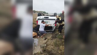 Good Samaritans help a woman out of her overturned car