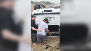 Good Samaritans help a woman out of her overturned car