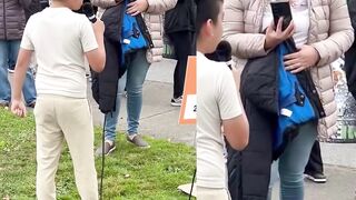 Smiling Latina mother films her son at an anti-ICE protest as he chants “Fuck ICE "
