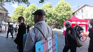 Transgender lunatic threatens man holding a sign that reads “Trans women are men.”