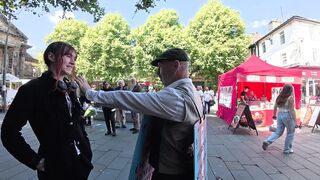 Transgender lunatic threatens man holding a sign that reads “Trans women are men.”