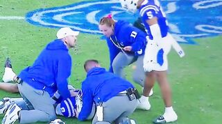 A Duke football player SWATS at a female medical staff worker on the field