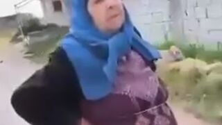 A Shia mother standing beside the bodies of her sons who were killed by HTS
