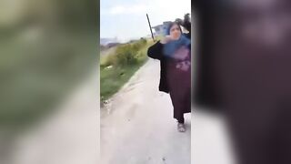 A Shia mother standing beside the bodies of her sons who were killed by HTS