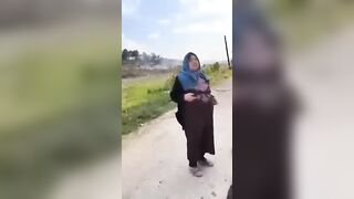 A Shia mother standing beside the bodies of her sons who were killed by HTS