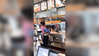 Woman holding her Baby helps Herself to the Chicken. Pay? nah