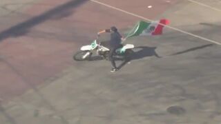 This LA,USA last night. Man on Live TV circles Burning Car waving the Mexican Flag