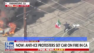 This LA,USA last night. Man on Live TV circles Burning Car waving the Mexican Flag