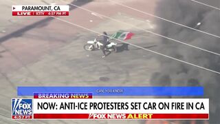 This LA,USA last night. Man on Live TV circles Burning Car waving the Mexican Flag