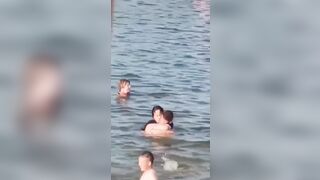 Lovebirds engage in debauchery in the water right next to swimming families