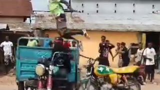 Pay Arrention: Motorcycle Taxi Funeral Celebration sends one Man down the Street (Slow Motion)
