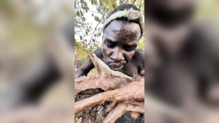 African man eating a fully cooked dog shows the variety of Human Behavior