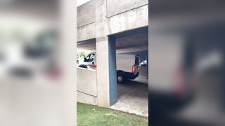 Man in a U-Haul van damaging the roof after driving into a parking garage